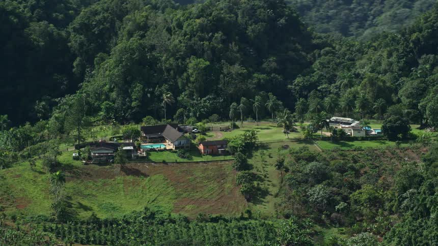 Aerial view of a house on top of a hill surrounded by vegetation