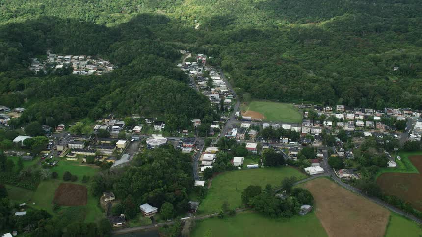 Aerial panorama of a small residential town amidst hills and mountains