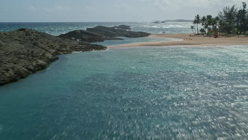 Aerial panorama of the sea and an island with clear waters on a sunny day with clouds
