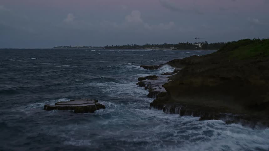 Strong waves hitting coastal rock formations at night