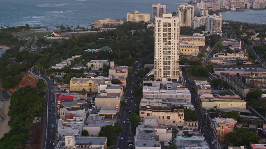 A city with tall buildings and a large street with some vehicles passing by