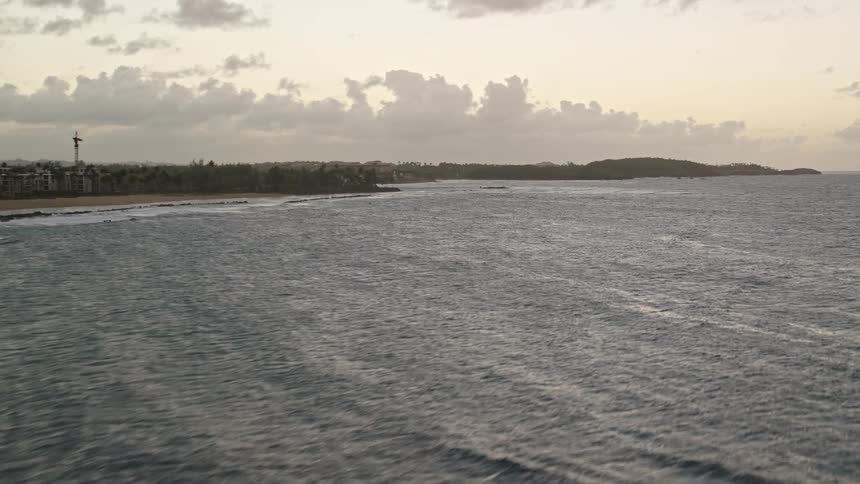 Panorama of a beach with a calm sea and tropical vegetation in the morning sky