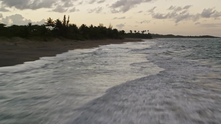 A beachfront with small waves crashing on the shore