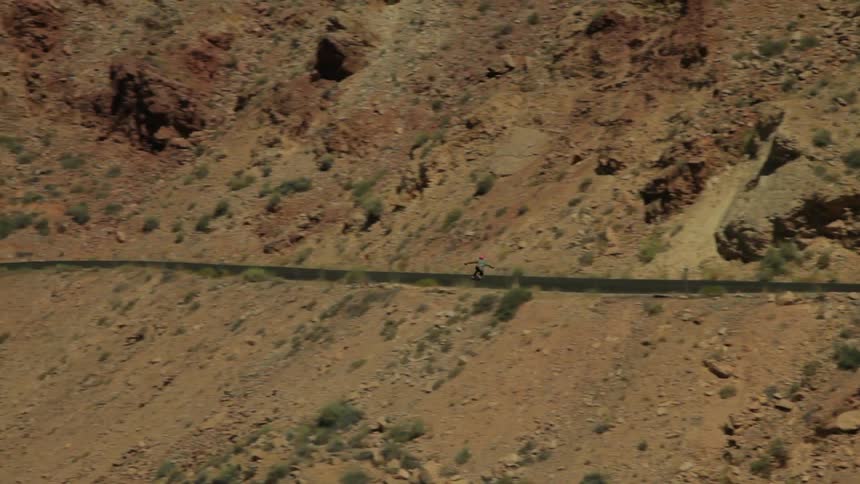 Person skateboarding on a road out in the desert