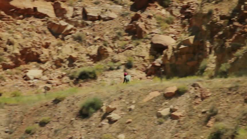 A skateboarder rides down a mountain road at a fast speed