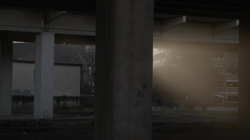 A car passes on a road behind a bridge