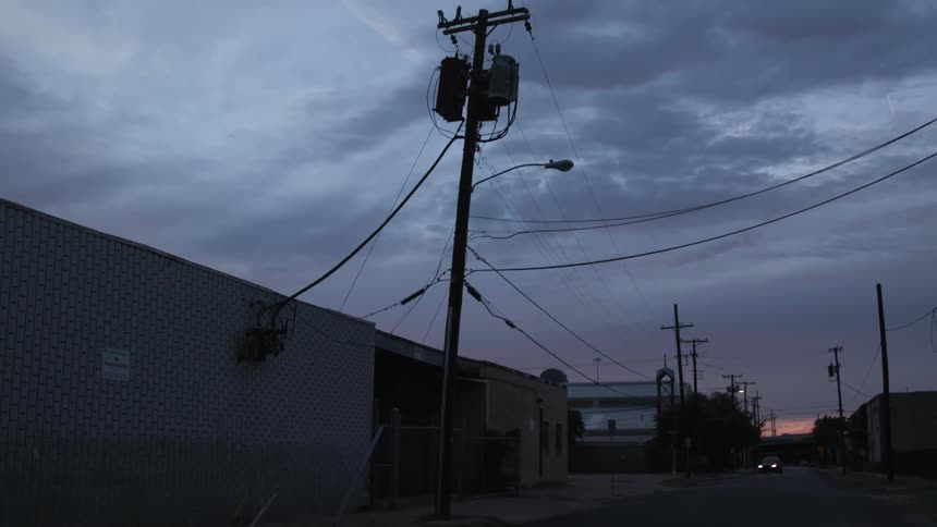 Power lines hang above a city street at night