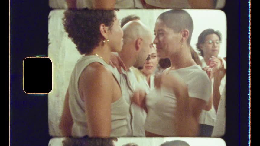 Group of models wearing white shirts dancing and smiling in a studio