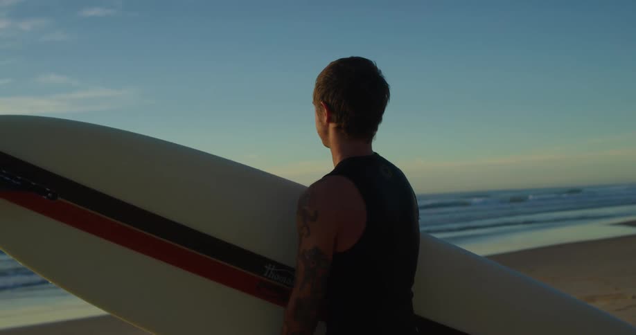 A man holding a surfboard at the coast