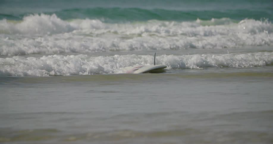 The waves carry the surfboard to shore