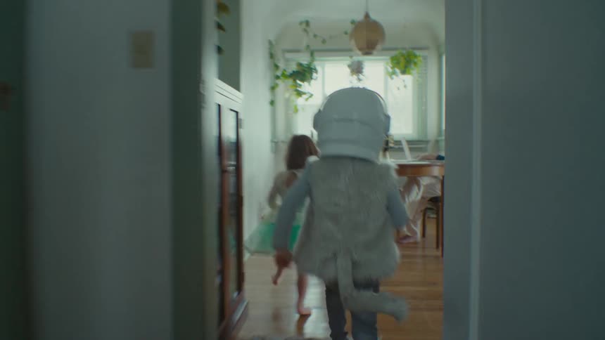 Some kids playing and running around a house together