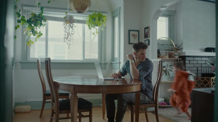 A father tries to work while his children play