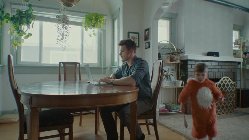 Father tries to work from home while his children play around