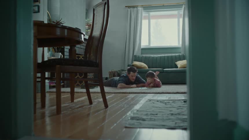 Father lying on the floor with his son playing a board game
