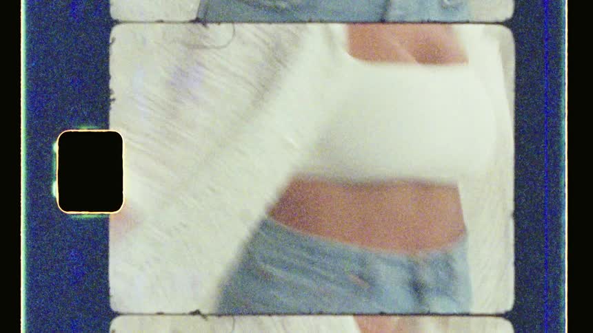 Model wearing a white shirt and jeans dancing and smiling a lot in a studio