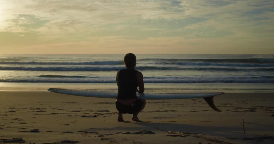 A surfer with his board on a beach
