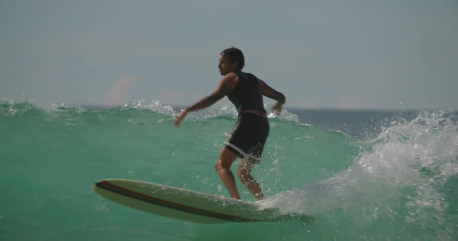 A man surfing on the sea waves at midday