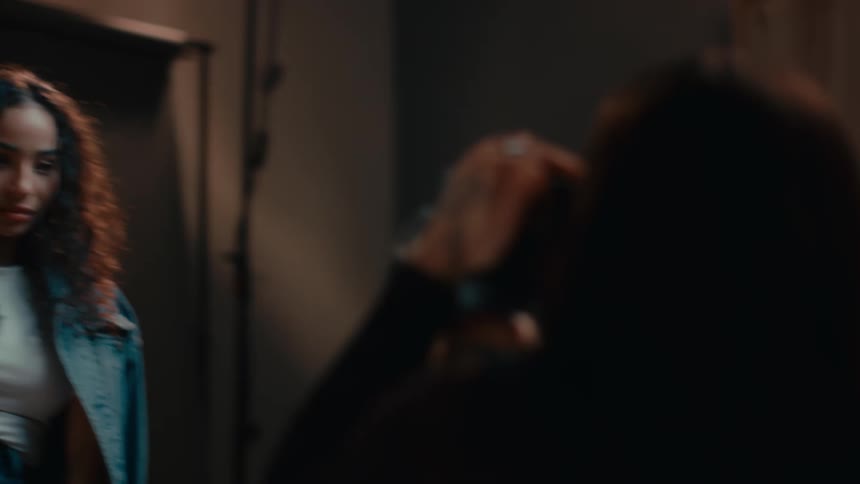 Woman modeling clothes is filmed with a vintage film camera