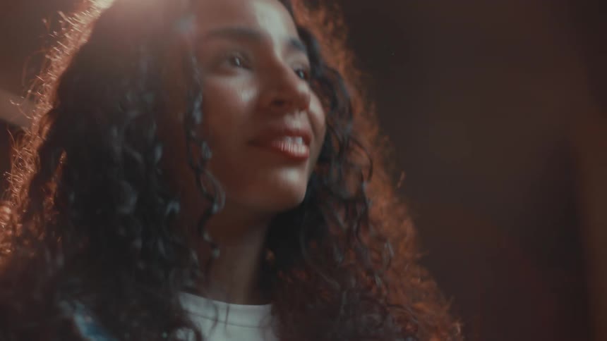 Portrait of a smiling young woman with black curly hair