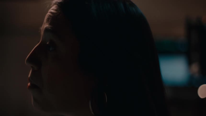 Head of a lady talking in a dark room