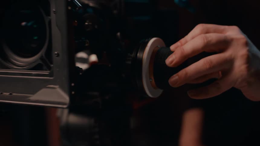 Close up of a hand turning a knob in a film camera