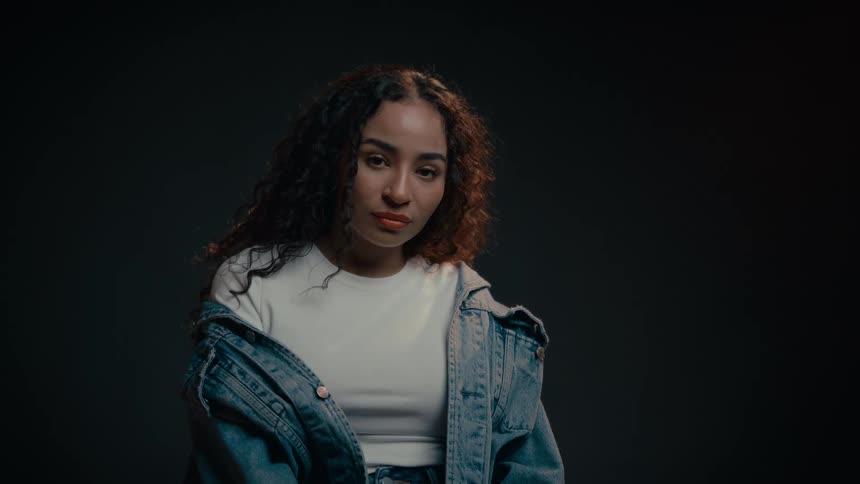 A female model adjusts her hair jeans coat and pose for a shoot