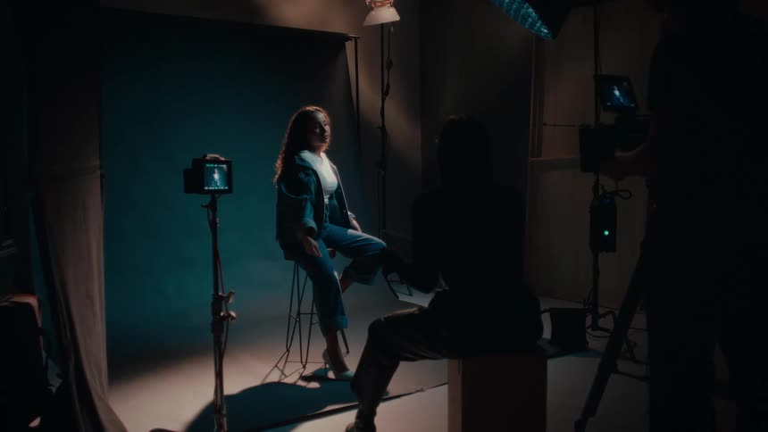 A woman is posing in front of a camera