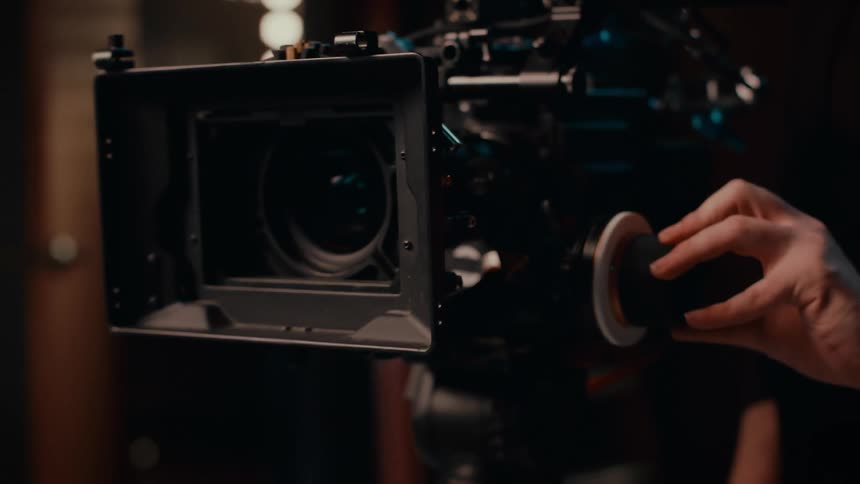 Woman holds knob on professional grade video camera