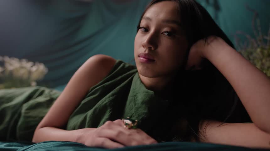 A young asian woman turns her head to stare
