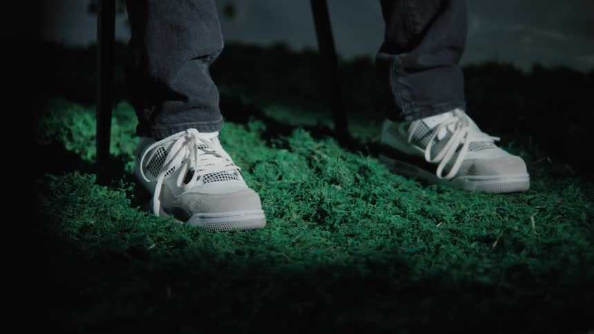 Closeup on the feet of a person sitting on a green rug