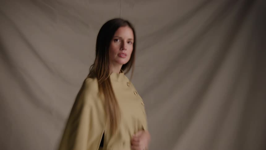 Woman modeling with an overcoat in a studio