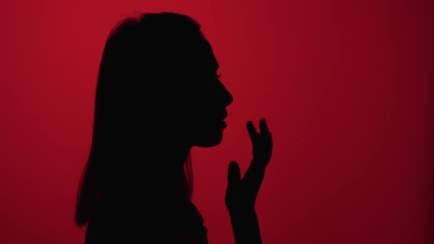A womans silhouette is in the red light