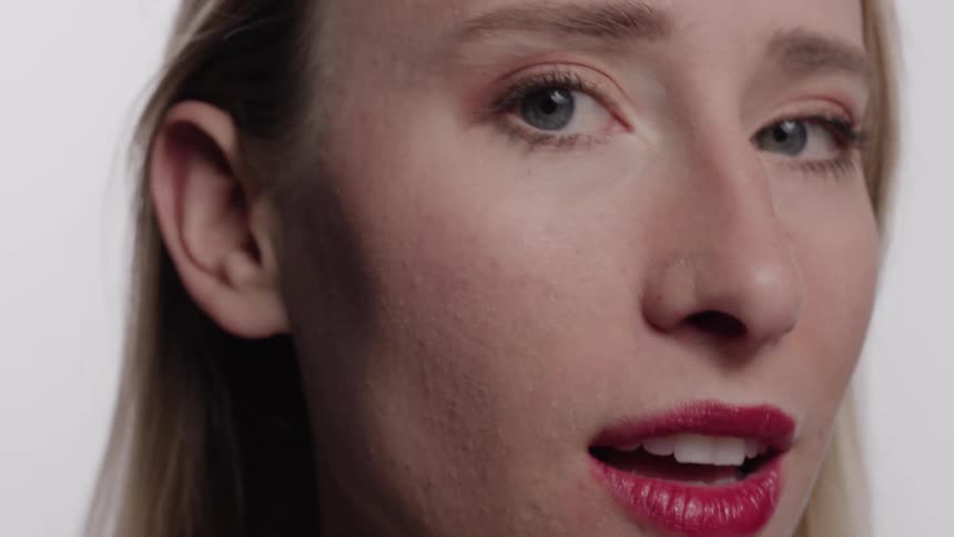A woman with red lipstick makes faces and smiles