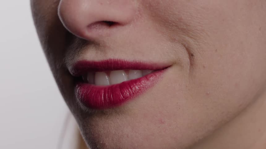 A woman with red lipstick smiles