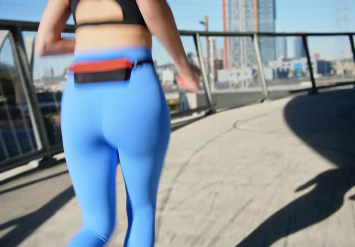 Back view of a woman running in an outdoor hallway