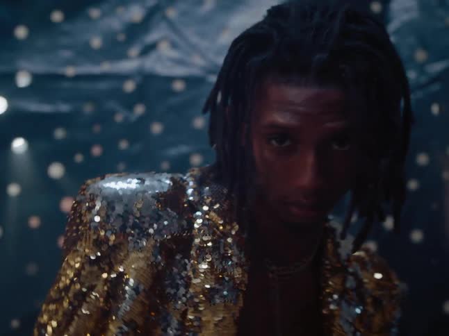 Male model poses in a gold shiny suit