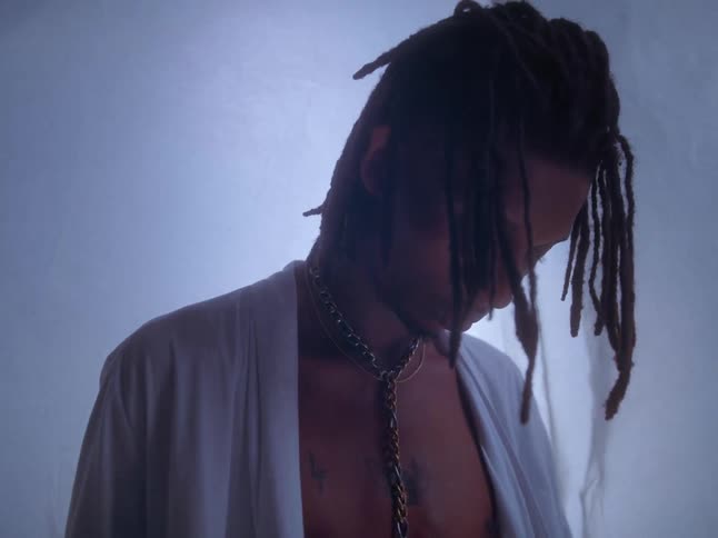 Man modeling with a satin robe in a studio