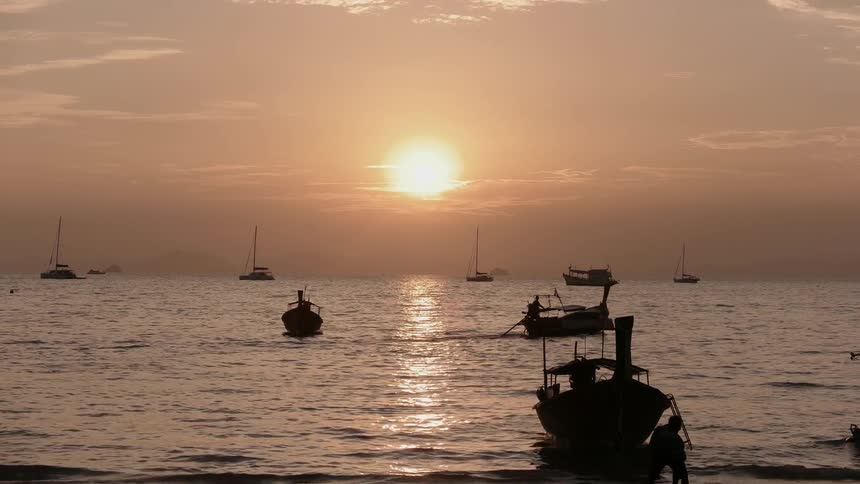 Boats are on the water as the sunsets