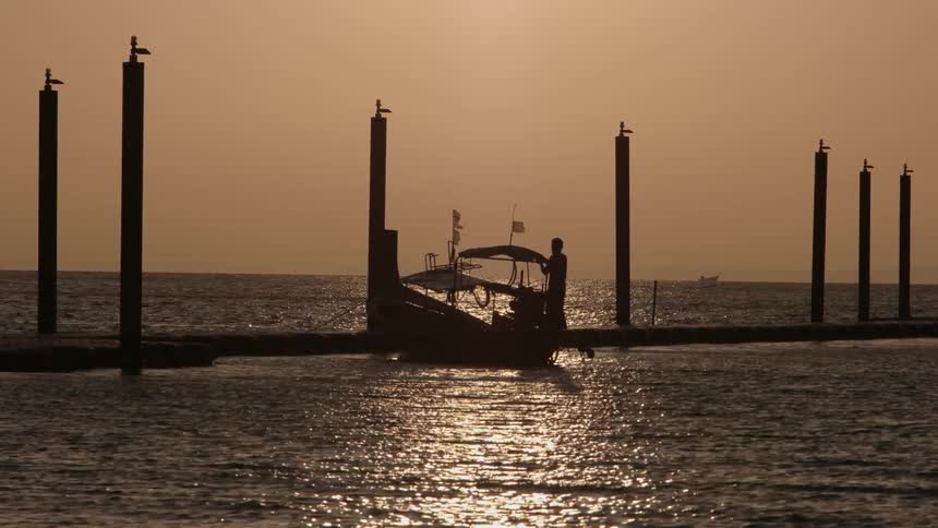 A person leaves a boat and walks up a dock