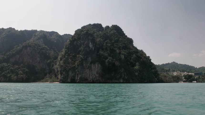 Sparkling blue water flows along the cliff lined shoreline