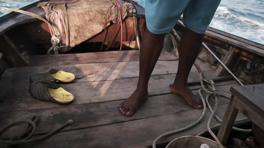 Person standing on a boat in the ocean