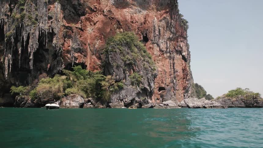 Lake water ripples with a rocky cliff in the background