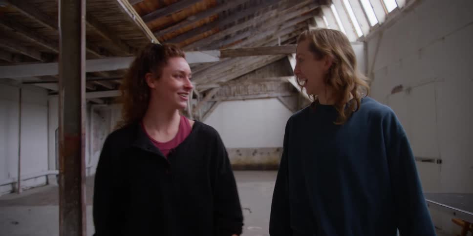 Two women walk talk and laugh