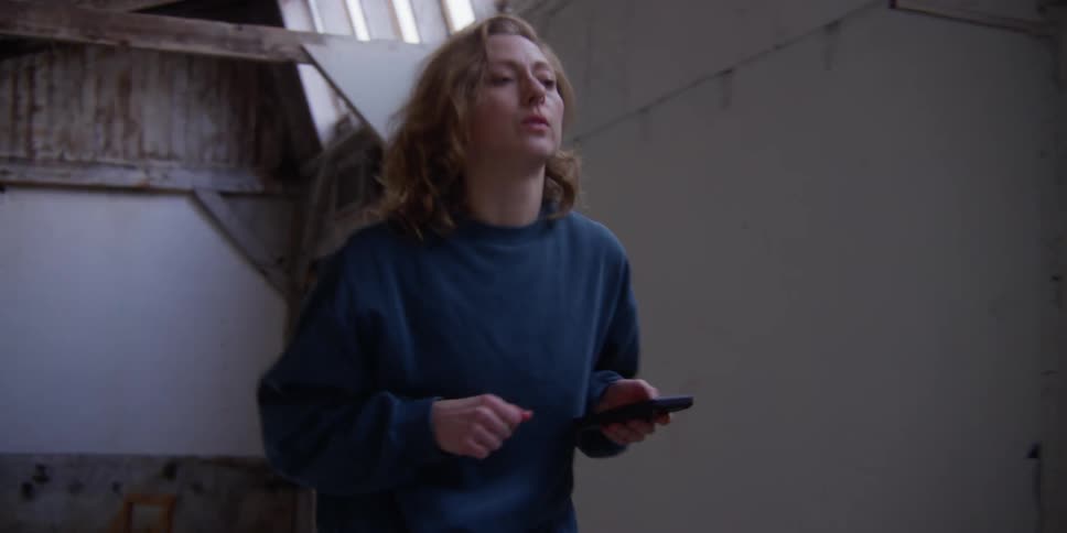 A woman with a smart phone performs dance moves