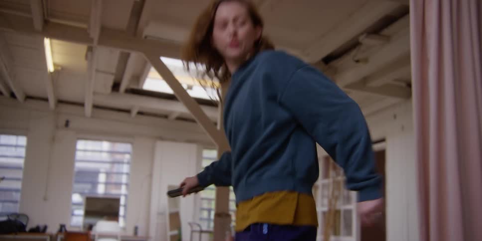 A woman dances with a cell phone in her hands listening to music