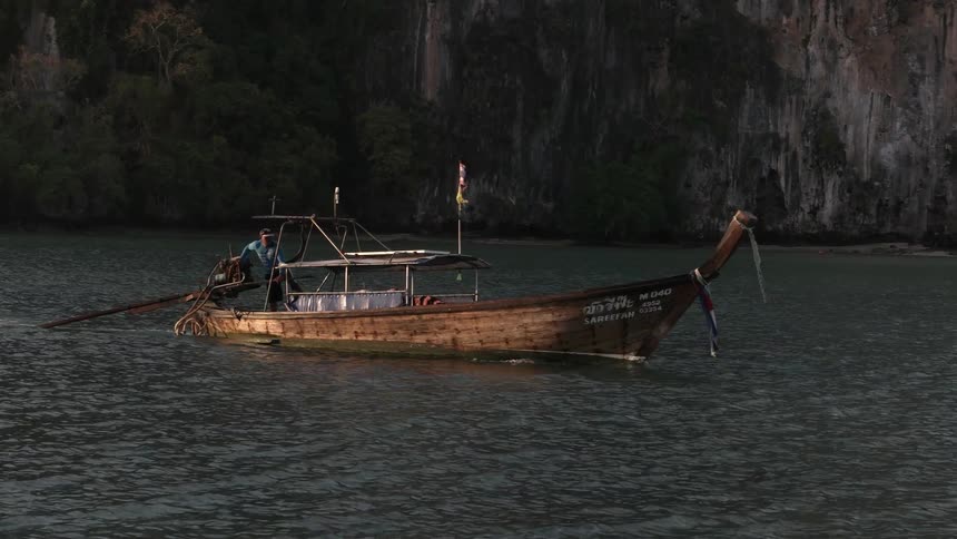 A man steers a boat down a waterway