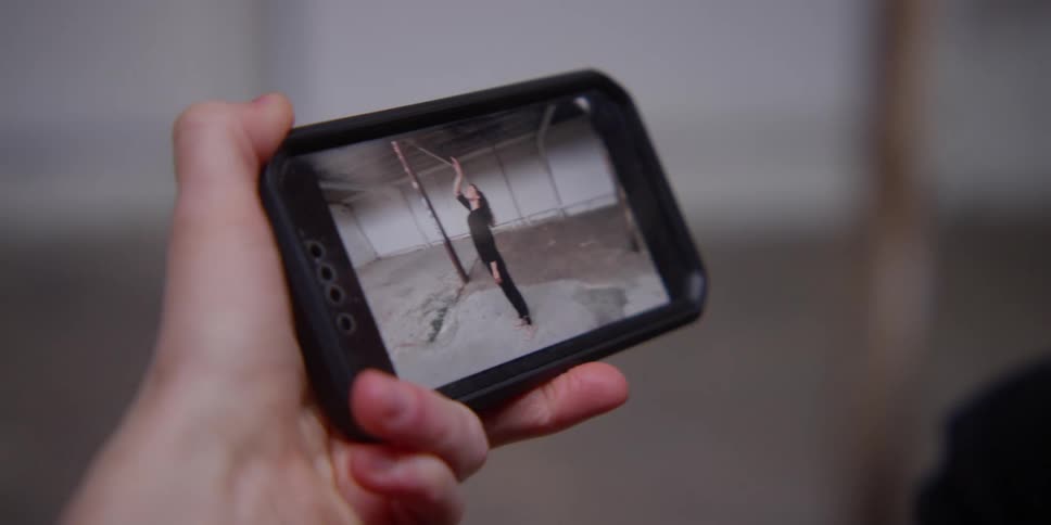 Closeup on an iphone reproducing a woman dancing