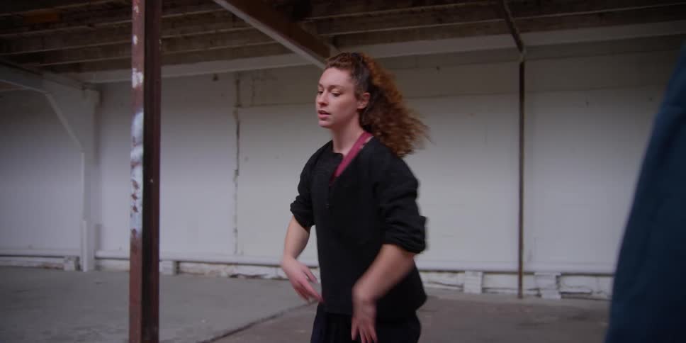 Choreographer guides dancer through routine in a dance studio