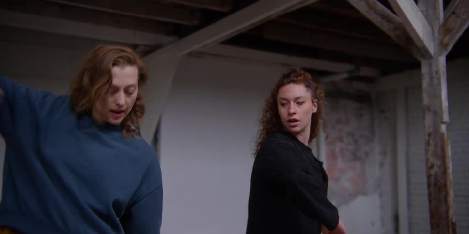 A woman teaches another woman some dance moves