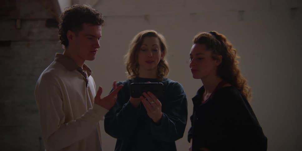 Friends looking at a cellphone and chatting